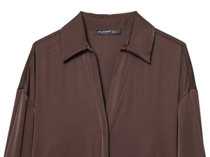 Close-up of silk-textured satin shirt collar with brand label and V-neckline detail