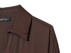 Close-up of dark brown satin shirt collar with precise stitching and brand label detail