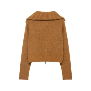 Detail of caramel knit cardigan with oversized collar and ribbed cuffs on plain background