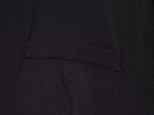 Detailed close-up of the fine twill texture and welt pocket stitching on black romper