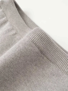 Macro detail of high-waist grey knit skirt showing ribbed texture and fine craftsmanship