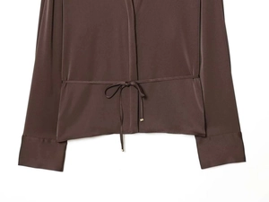 Detailed view of dark brown satin shirt featuring a drawstring waist and silky texture