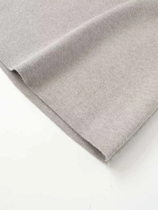 Detailed macro view of light gray knit fabric texture on a high-waisted pencil skirt