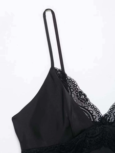 Détail de dentelle noire élégante sur une robe nuisette en satin lisse avec col en V