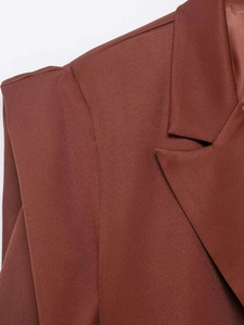 Detail shot of caramel brown blazer featuring sharp notched lapels and fine twill fabric