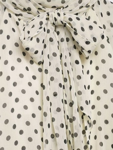 Close-up of pussy-bow tie neck and soft fabric texture on polka dot chiffon shirt