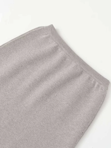 Detail of high waist elastic ribbed waistband on a light grey knit bodycon skirt