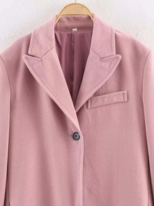 Detail of pink wool coat featuring a sharp peak lapel and premium smooth inner lining