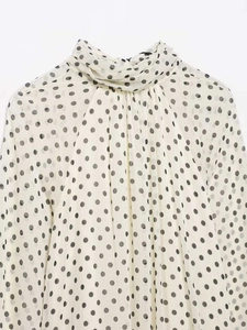 Detailed view of vintage polka dot chiffon blouse with elegant pleated high collar neckline