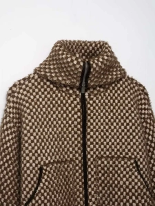 Detail of checkered plush jacket featuring a high collar and metal zipper closure