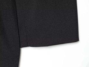 Close-up of the black twill fabric texture and durable stitching on the V-neck romper