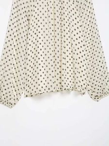 Detailed view of lightweight polka dot chiffon blouse with elastic ruffled lantern sleeves