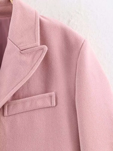 Detail of pink wool coat featuring notch lapels and textured weave fabric construction