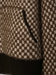 Macro shot of two-tone knit fabric texture with soft mohair feel and ribbed hem detail