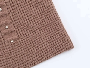 Close-up of brown ribbed knit cardigan featuring decorative silver metal buttons