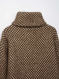 Close-up of fluffy checkered knit sweater featuring high-neck design and plush texture