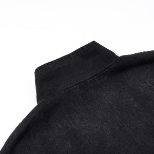 Detailed close-up of collar stitching and washed denim texture on black jacket
