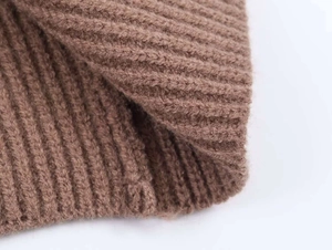Detailed macro view of the thick brown ribbed knit fabric showing soft texture and elasticity