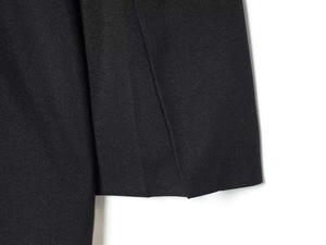 Detailed close-up of premium black twill fabric with V-neck romper stitching details