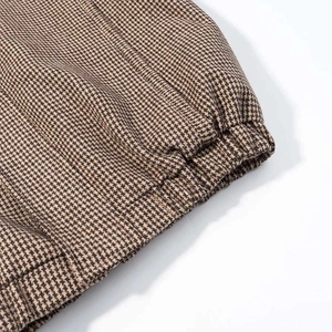 Detail of the elastic cuff and brown houndstooth pattern fabric on the flight jacket