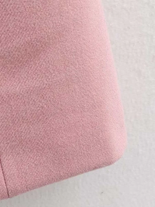 Close-up of pink wool blend tweed fabric showing detailed woven texture on coat