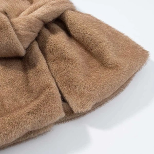 Vue détaillée de la texture de fausse fourrure camel avec un élégant nœud croisé