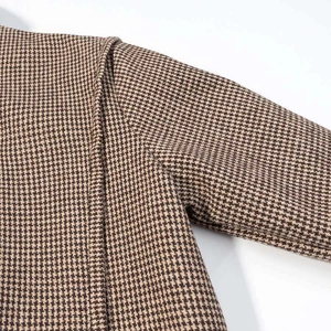 Detail shot of vintage houndstooth jacket showing brown fabric texture and seam stitching