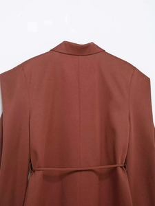 Detail of caramel brown waist-tie blazer featuring a sleek back seam and tailored fit