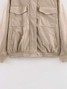 Detail of beige faux suede jacket featuring large flap chest pockets and elastic hem
