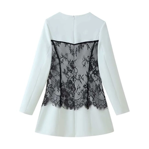 Detail of white mini dress featuring black floral lace patchwork and eyelash fringe back