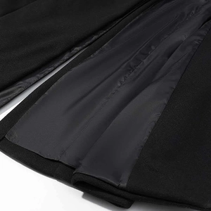 Detailed view of heavy black wool texture and smooth satin lining on a long coat
