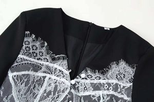 Close-up of V-neck dress featuring delicate white floral lace and ball buttons