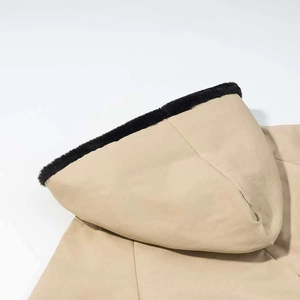 Dettaglio del parka kaki con bordo in ecopelliccia nera sul cappuccio e tessuto liscio