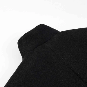 Detail view of the black woolen fabric and stitching on the elegant long overcoat collar