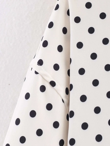Detailed stitching on beige fabric with black polka dots for a long-sleeved jacket