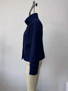 Detail view of navy blue stand-up collar jacket on mannequin with button accents