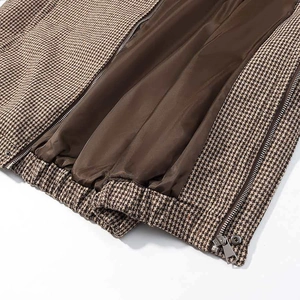 Close-up of brown houndstooth jacket featuring smooth satin lining and silver zipper