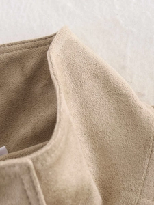 Detail shot of stand collar and faux suede fabric texture on a beige short jacket