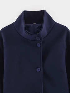 Close-up of the standing collar and navy wool-blend fabric with textured buttons