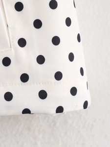 Close-up of polka dot fabric texture with precise double stitching on the bottom hemline