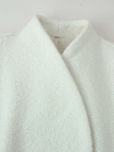 Close-up of a white textured wool jacket collar with minimalist overlap design details