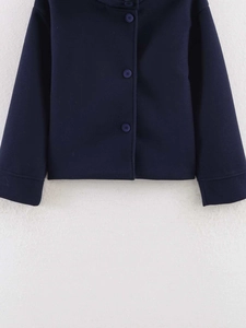 Detail view of navy blue wool jacket showing button closure and fabric texture