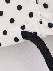 Detailed close-up of black polka dot fabric with high-quality drawstring and stitching