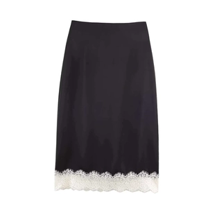 Détail d'une jupe mi-longue en satin noir avec bordure en dentelle blanche élégante