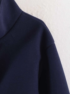 Detail view of navy blue wool jacket neckline with high-quality stitching and fabric texture