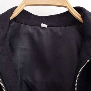 Women's black sequin jacket with metal zipper closure and ribbed collar on wooden hanger