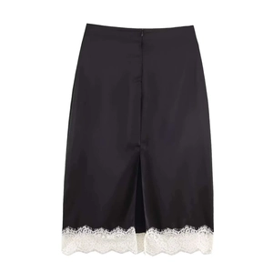Détail d'une jupe mi-longue en satin noir avec dentelle blanche et fente arrière