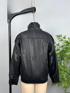 Detail view of the grain leather texture and V-shaped stitching on the black jacket back