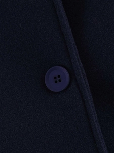 Detailed macro view of navy wool jacket featuring premium texture and four-hole button