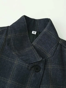 Close-up of vintage grey plaid blazer collar showing the size M label and fine texture